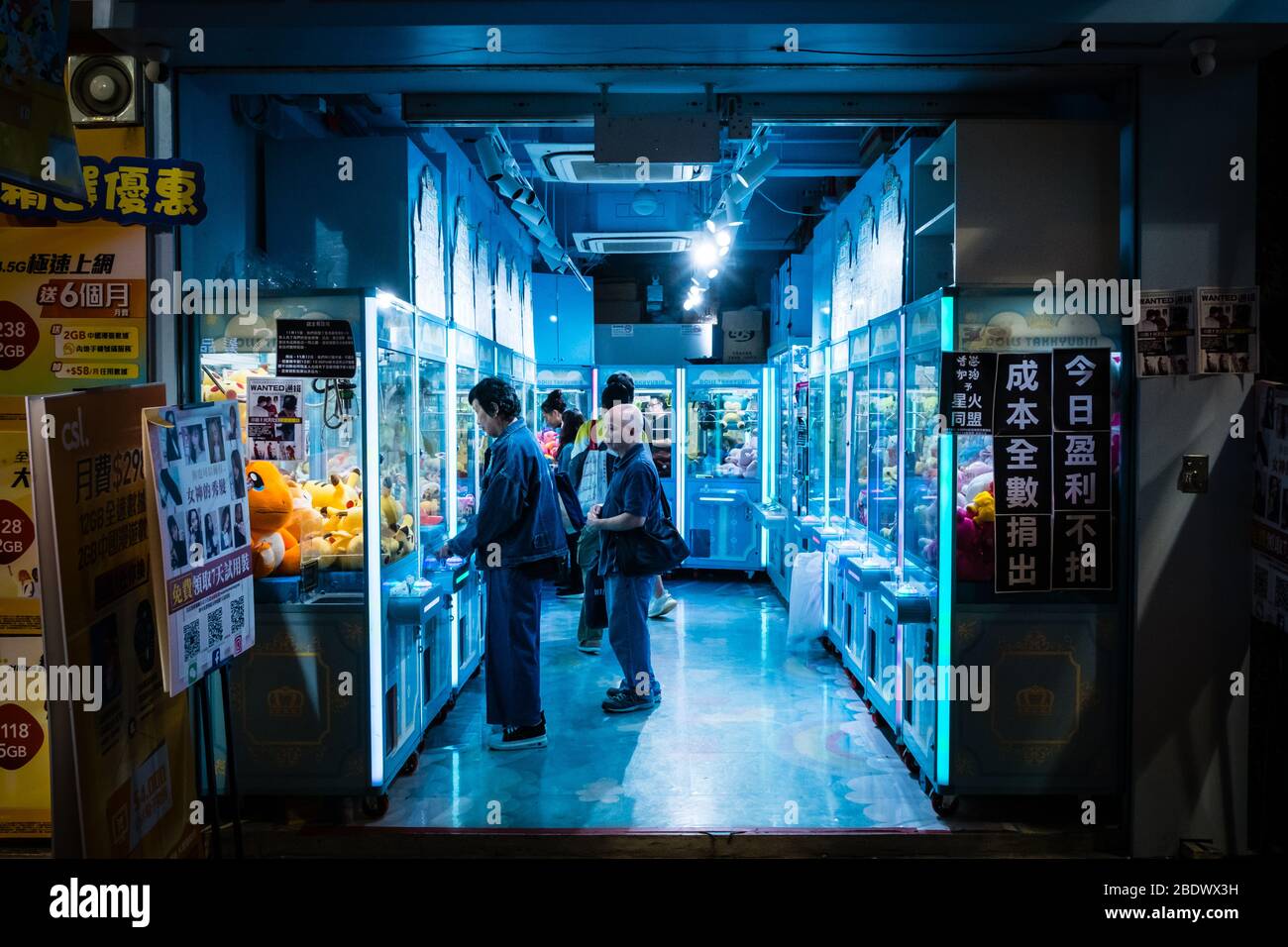 Hongkong, November 2019: Menschen, die auf einem Kran spielen, greifen nachts in Hongkong einen Spielautomaten Stockfoto