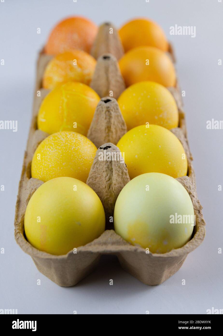 Verschiedene Schattierungen von gelben Eiern in einem Papierbehälter. Ostereier. Stockfoto