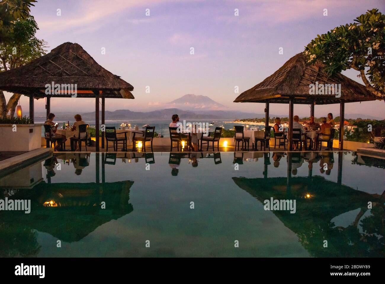 Horizontale Ansicht einer Restaurantterrasse mit Blick auf den Mount Agung bei Sonnenuntergang auf Lembongan Island, Indonesien. Stockfoto