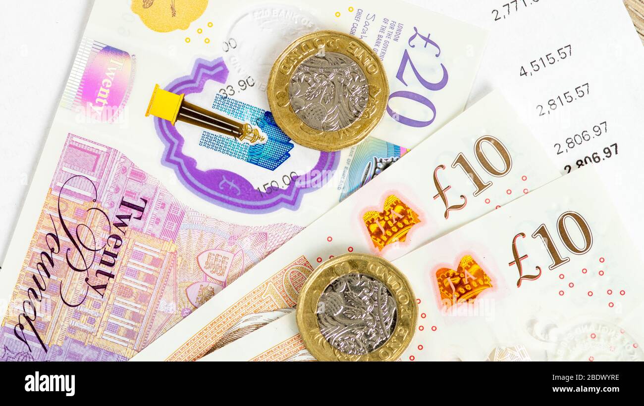 Britische Währung flach legen Pfund Münzen über zehn und zwanzig Pfund-Noten Stockfoto