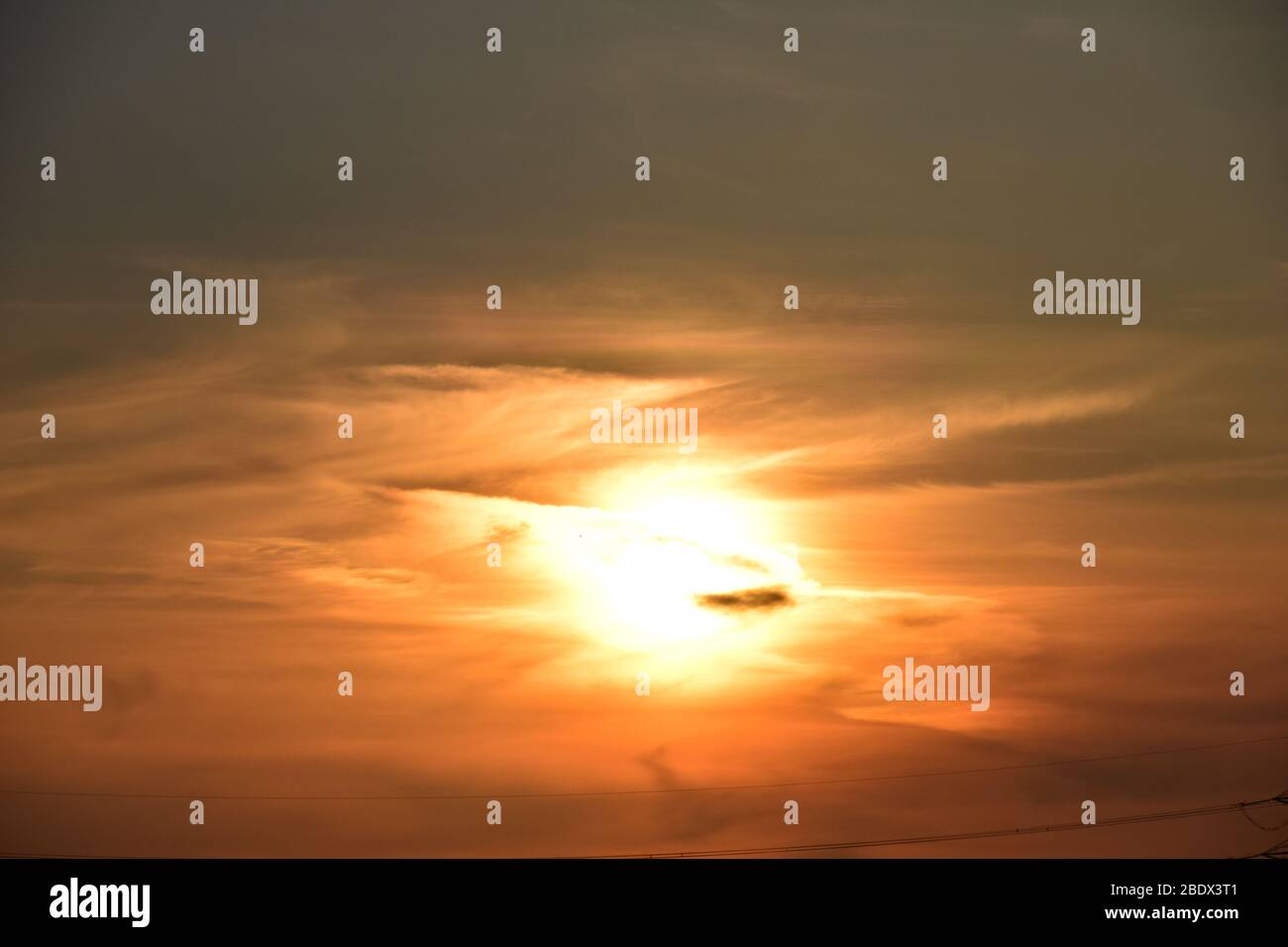 Untergehende Sonne untergegangen in einem Schwad rot und orange hued Wolkenformationen, die eine überirdische Apperance geben. Stockfoto
