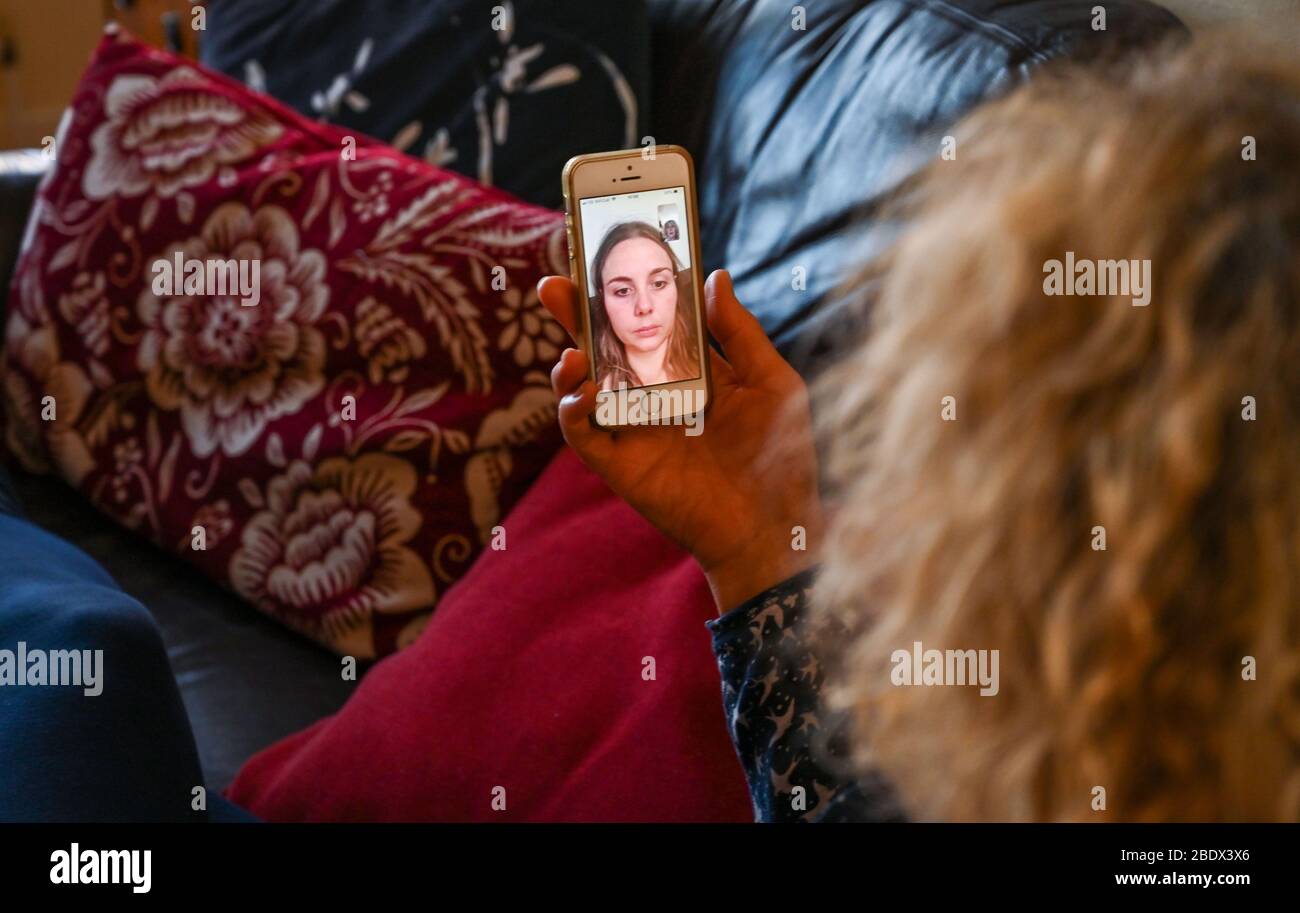 Junge Frau spricht mit Mutter auf Apple iPhone mit FaceTime während der Coronavirus Sperrung UK Foto von Simon Dack aufgenommen Stockfoto