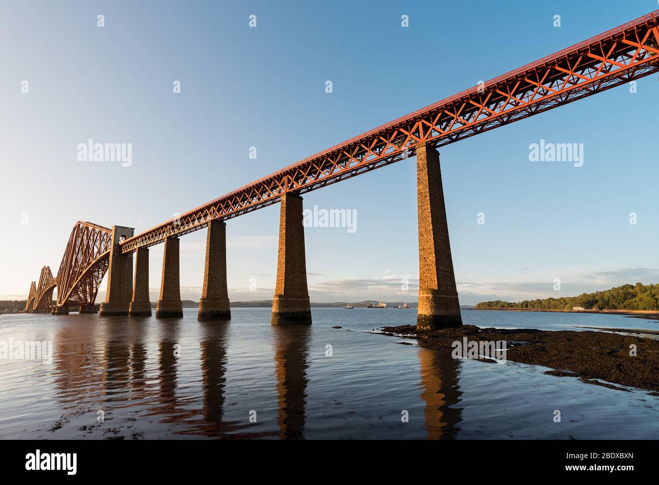 Die Forth Rail Bridge, die bei Sonnenuntergang den Firth of Forth überquert, Edinburgh, Schottland. Stockfoto