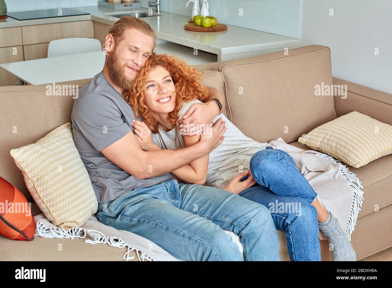 Junge Erwachsene Mann und Frau umarmen sich und lächeln weit Stockfoto