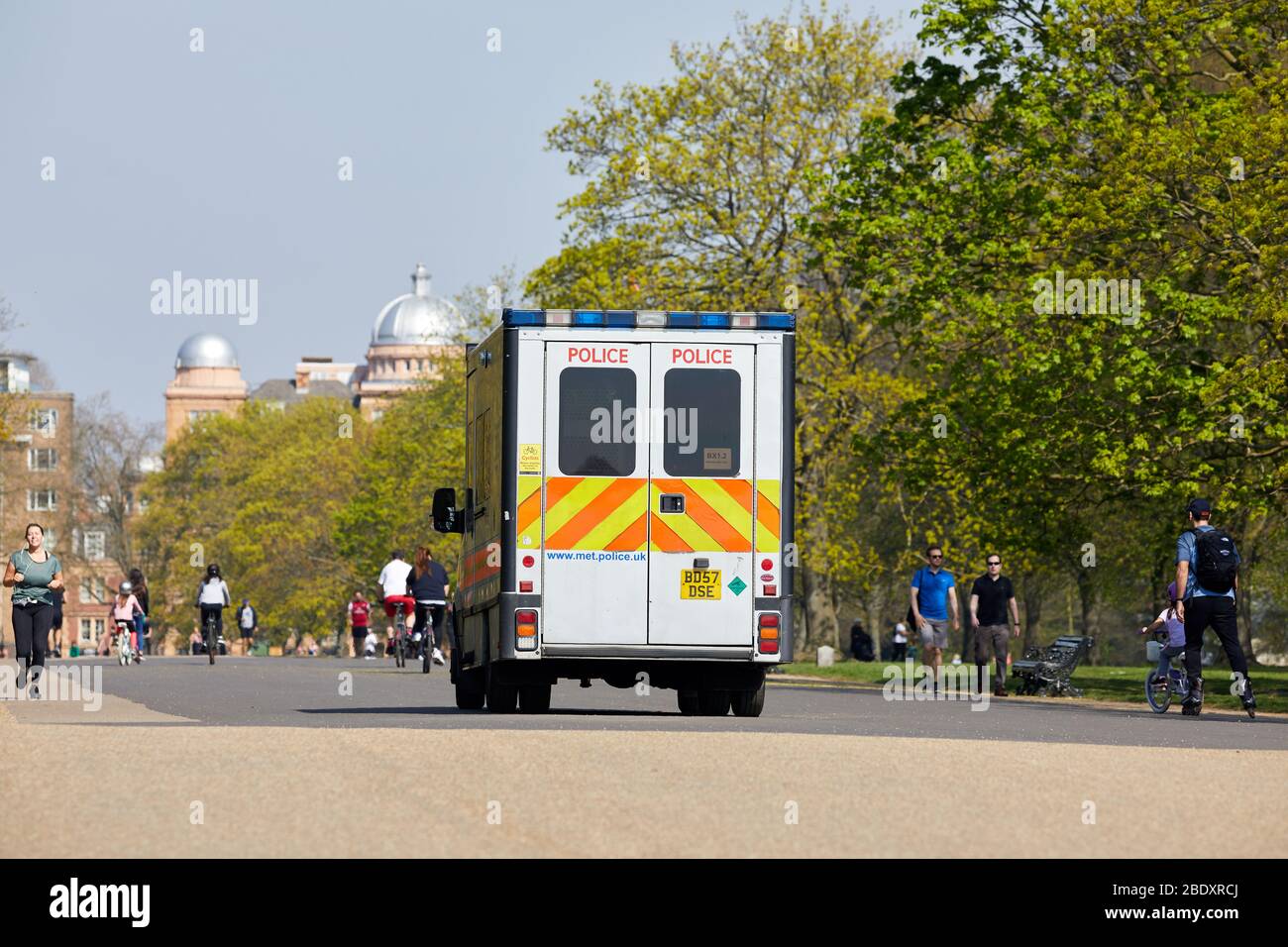 London, Großbritannien - 10 Apr 2020: Ein Polizeiwagen patrouilliert Kensington Gardens, während die Menschen ihre erlaubte Übung während der Sperrung des Coronavirus machen. Stockfoto