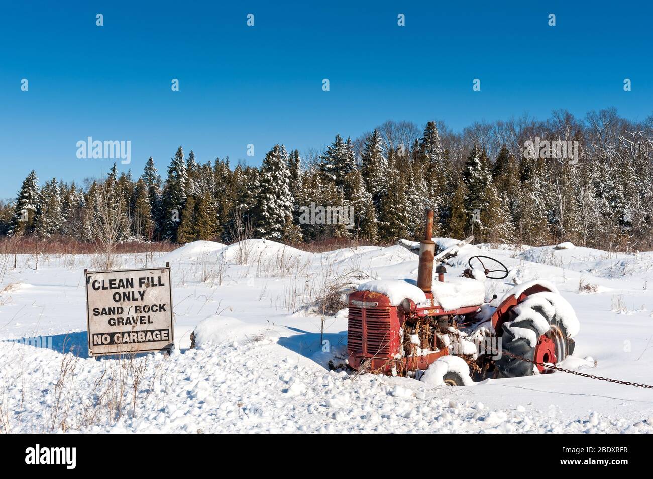 Winterszene mit schneebedecktem Vintage-Traktor Stockfoto