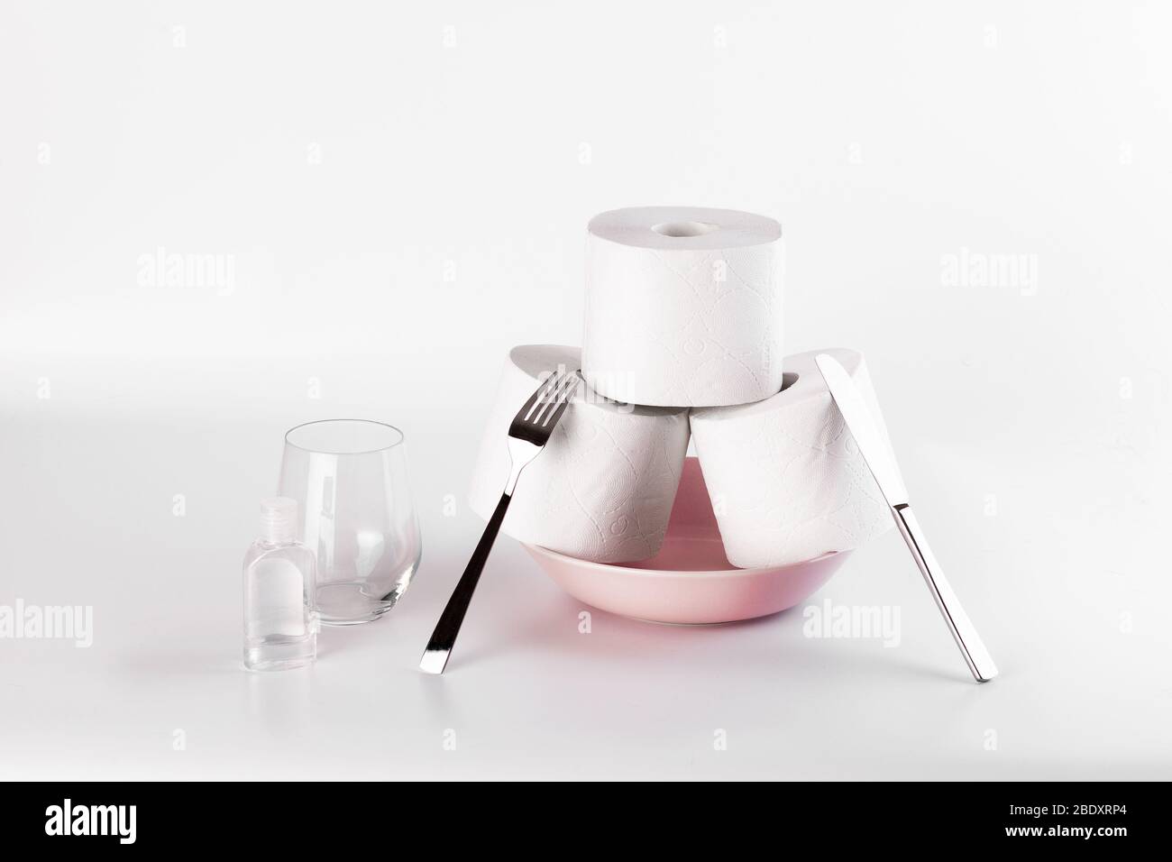 Toilettenpapier über Kauf Hysterie während Coronavirus. WC-Papierstapel auf einem Teller mit Messer und Gabel. Stockfoto