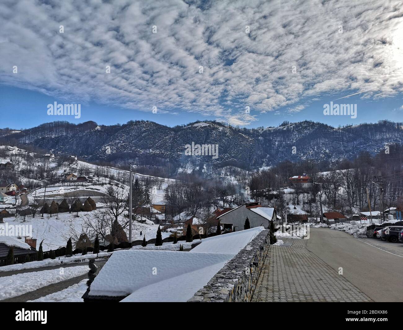 Foto von Bergen in Rumänien, verschneite Landschaft mit Wolkenformationen, blauer Himmel und die Karpaten Bergkette in Ponoarele, Mehedinti - 01/01/2019 Stockfoto