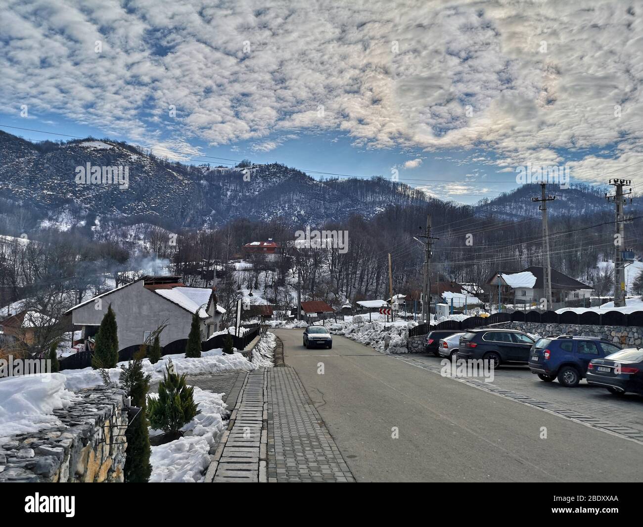Landschaft im rumänischen Teil der Karpaten, schneebedeckte Gipfel und Wolkenformationen über Ponoarele Dorf in Mehedinti, Rumänien - 01/01 Stockfoto