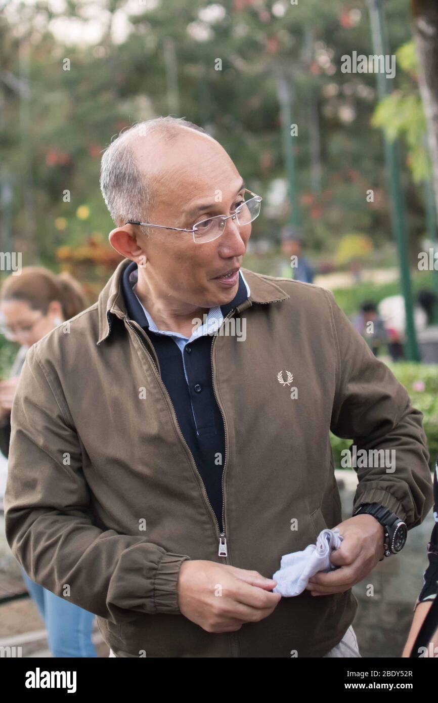 28. NOVEMBER 2019-BAGUIO STADT PHILIPPINEN: Bürgermeister von Baguio Stadt Philippinen gewählt, Bürgermeister Benjamin Magalong, lächelnd und mit der Menge auf Augenhöhe zu sprechen Stockfoto