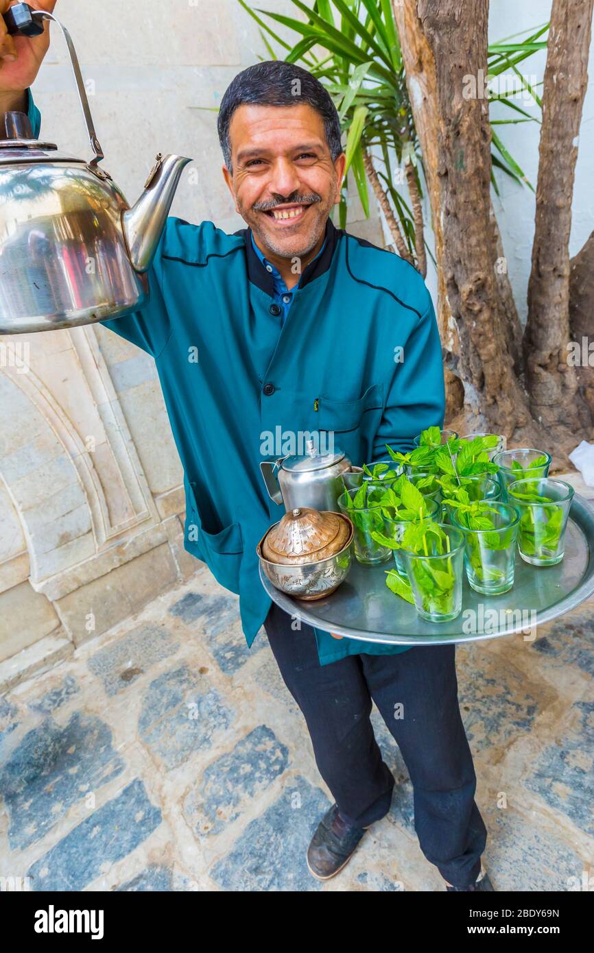 Mann gießt Minztee in Medina. Stockfoto