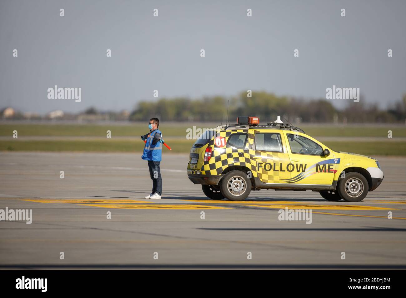 Otopeni, Rumänien - 8. April 2020: Flughafenmitarbeiter führt ein Landeflugzeug auf dem Henri Coanda International Airport. Stockfoto