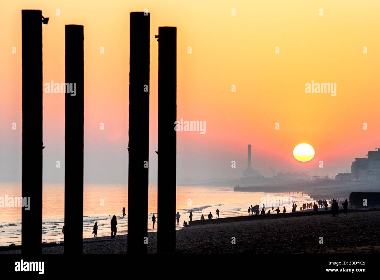 Brighton, Großbritannien, 08. April 2020, Menschen am Strand von Brighton, die den Sonnenuntergang beobachten Stockfoto