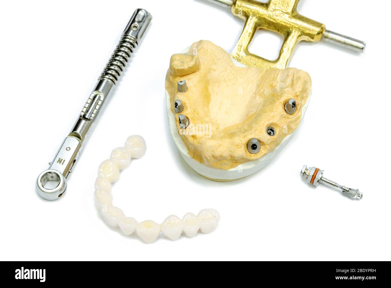 Weiße keramische Zähne mit Zahnimplantaten auf weißem Hintergrund. Drehmomentschlüssel und Schraubendreher. Konzept der dentalen Implantation und orthopädische de Stockfoto