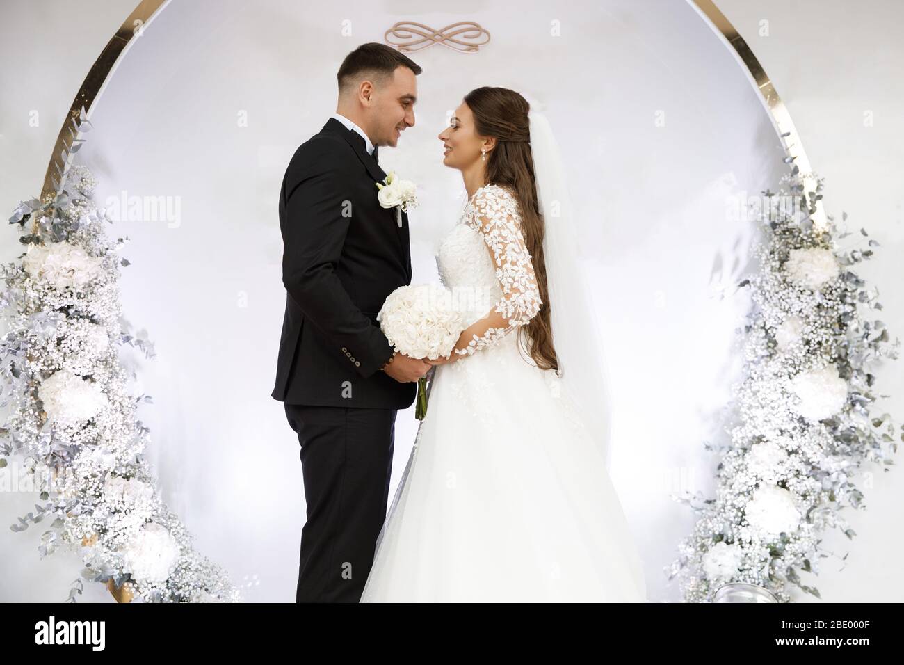 Ein paar Bräute stehen am Hochzeitstag am Bogen. Stockfoto