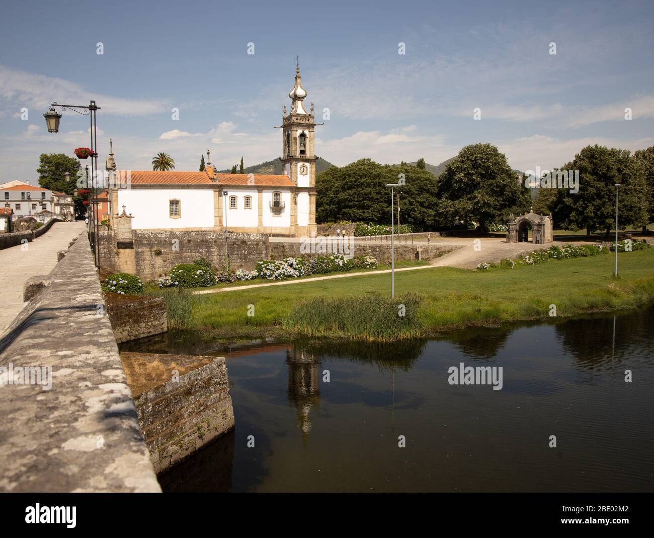 Blick auf den Fluss Lima durch die Brücke Ponte Medieval und die weiße hübsche Kirche Igreja de Santo António Ponte de Lima Nord Portugal Stockfoto