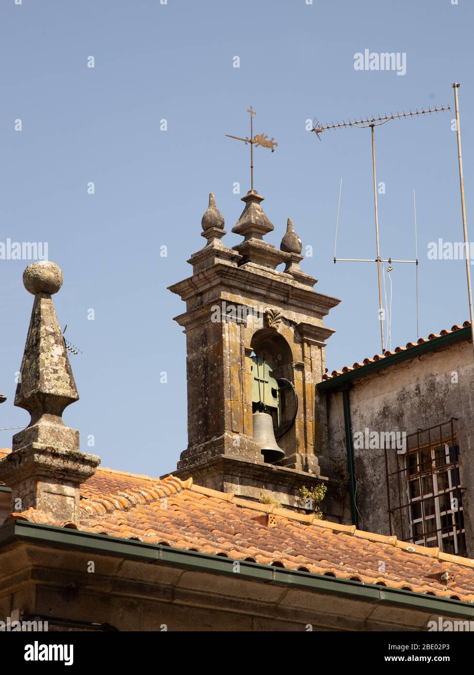 Traditionelle Kacheldach Kirchenglocke und TV-Antennen gegen einen blauen Himmel in Ponte de Lima Nord Portugal Stockfoto