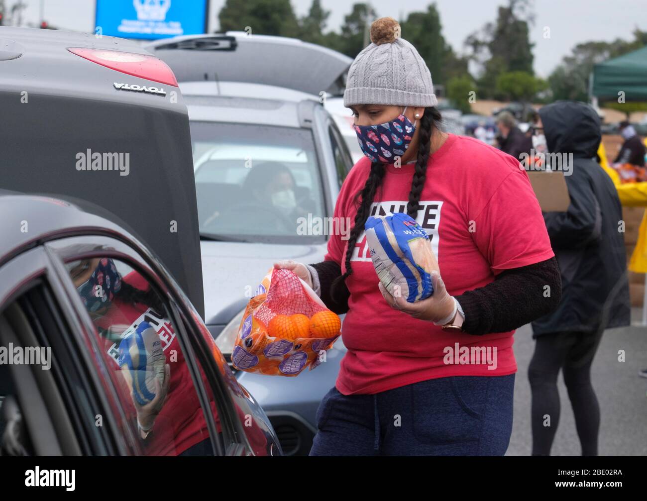 Los Angeles, Kalifornien, USA. April 2020. Ein Gewerkschaftsmitglied lädt Lebensmittel während einer Fahrt durch die Lebensmittelverteilung durch die L.A. in den Kofferraum eines Fahrzeugs Regionale Lebensmittelbank am Parkplatz des Forums am Freitag in Inglewood. Kredit: Ringo Chiu/ZUMA Wire/Alamy Live News Stockfoto