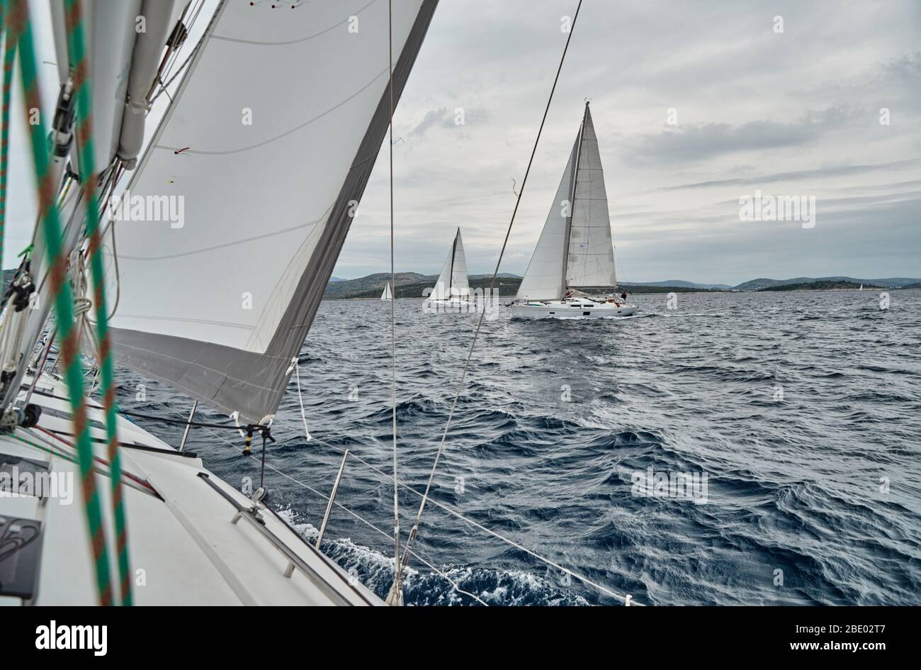Kroatien, Adria, 19. September 2019: Das Rennen der Segelboote, sitzt das Team am Rande eines Bootstafel, helle Farben, Blick der Teilnehmer Stockfoto