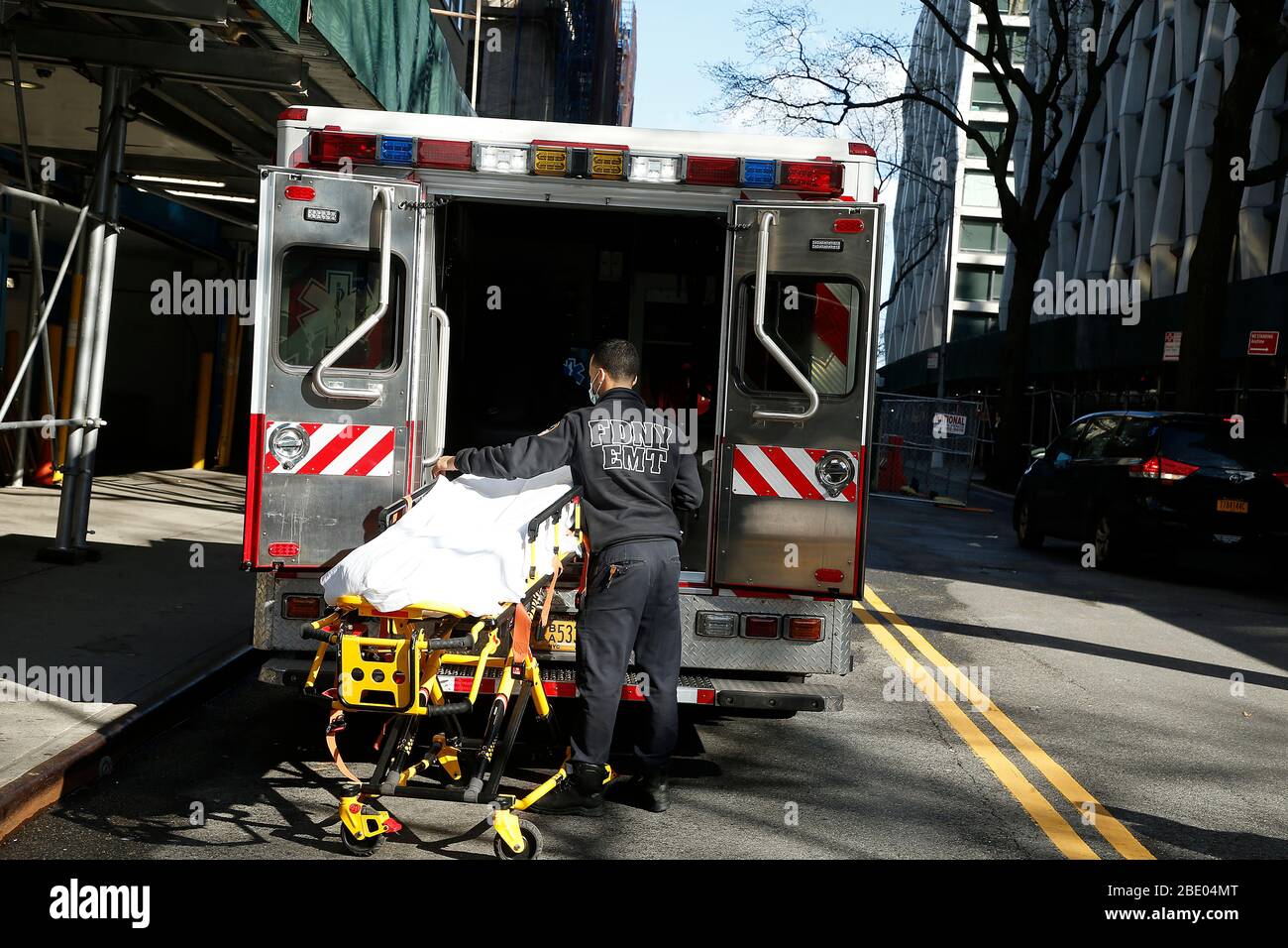 Ein Notarzt bereitet eine Liege vor, die für den Transport eines COVID-19 Patienten verwendet werden kann.Krankenhäuser in New York City sind von der COVID-19-Pandemie schwer getroffen worden und sehen sich mit einem Mangel an Betten, Ventilatoren und Schutzausrüstung sowie extrem langen Schichten für das medizinische Personal konfrontiert. Stockfoto