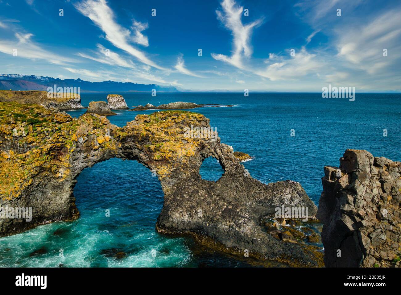 Gatklettur Felsformationen auf der Halbinsel Snaefellsnes und dem atlantik an sonnigen Tagen. Schönes blaues Wasser und klarer blauer Himmel. Keine Personen sichtbar, kopieren Stockfoto