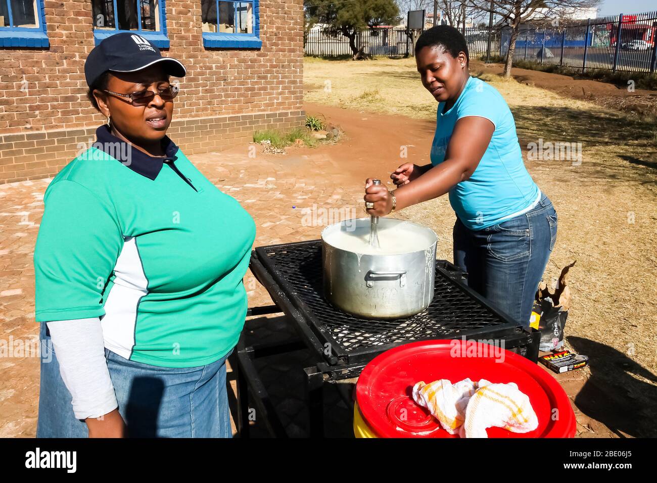 Soweto, Südafrika - 21. Juli 2012: Afrikanische Frau kocht Mielie Pap-Maisbrei auf der Seitenstraße im städtischen Soweto Stockfoto