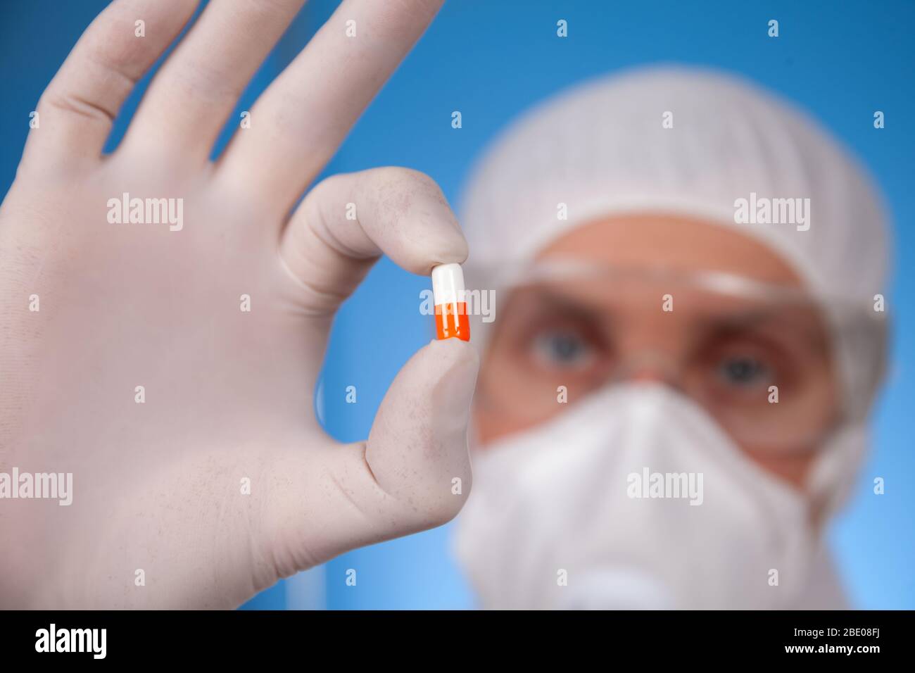 Arzt in der schützenden Arbeitskleidung zeigen die Pille Stockfoto