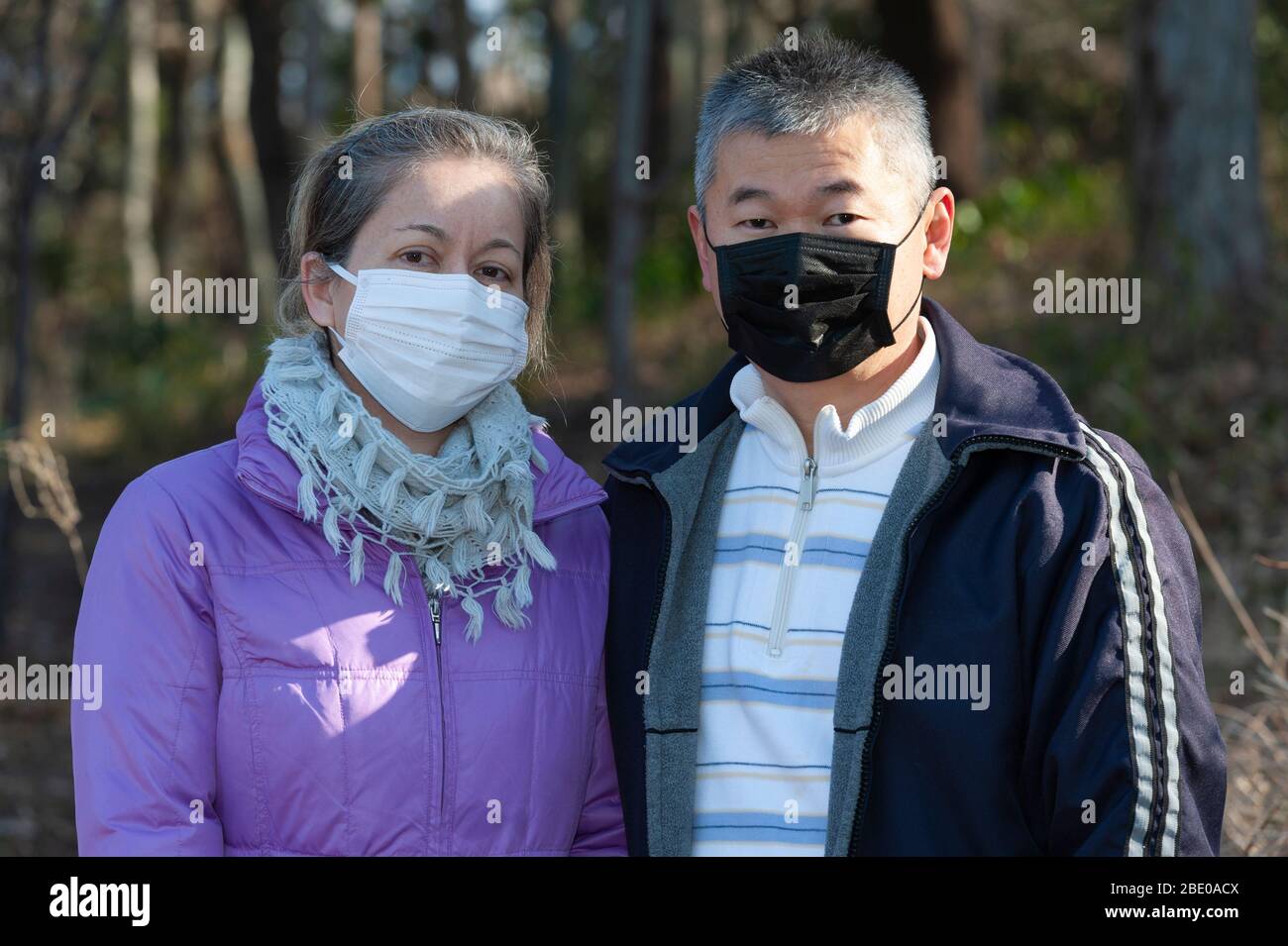 Ein Paar mittleren Alters, das eine Maske (weiße Maske und schwarze Maske) zum Schutz gegen Coronavirus COVID-19 (SARS-CoV-2) und andere Infektionskrankheiten trägt. Stockfoto