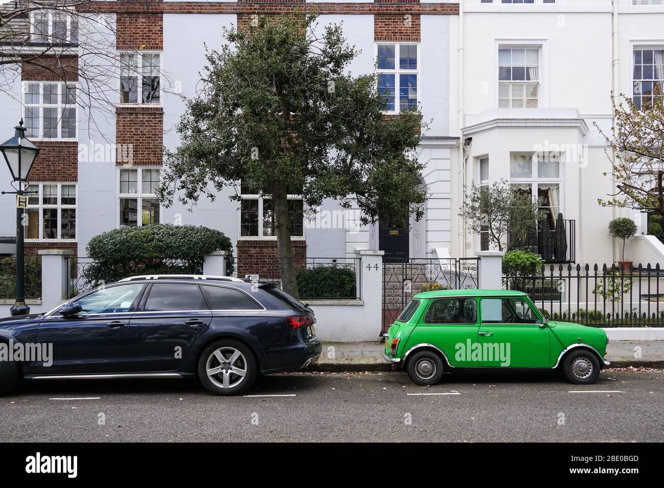 Altes zweitüriger Oldtimer Morris Mini Cooper, der nebenan geparkt hat Modernes Audi A4 Avant Auto vor Wohngebäuden London England Vereinigtes Königreich Großbritannien Stockfoto