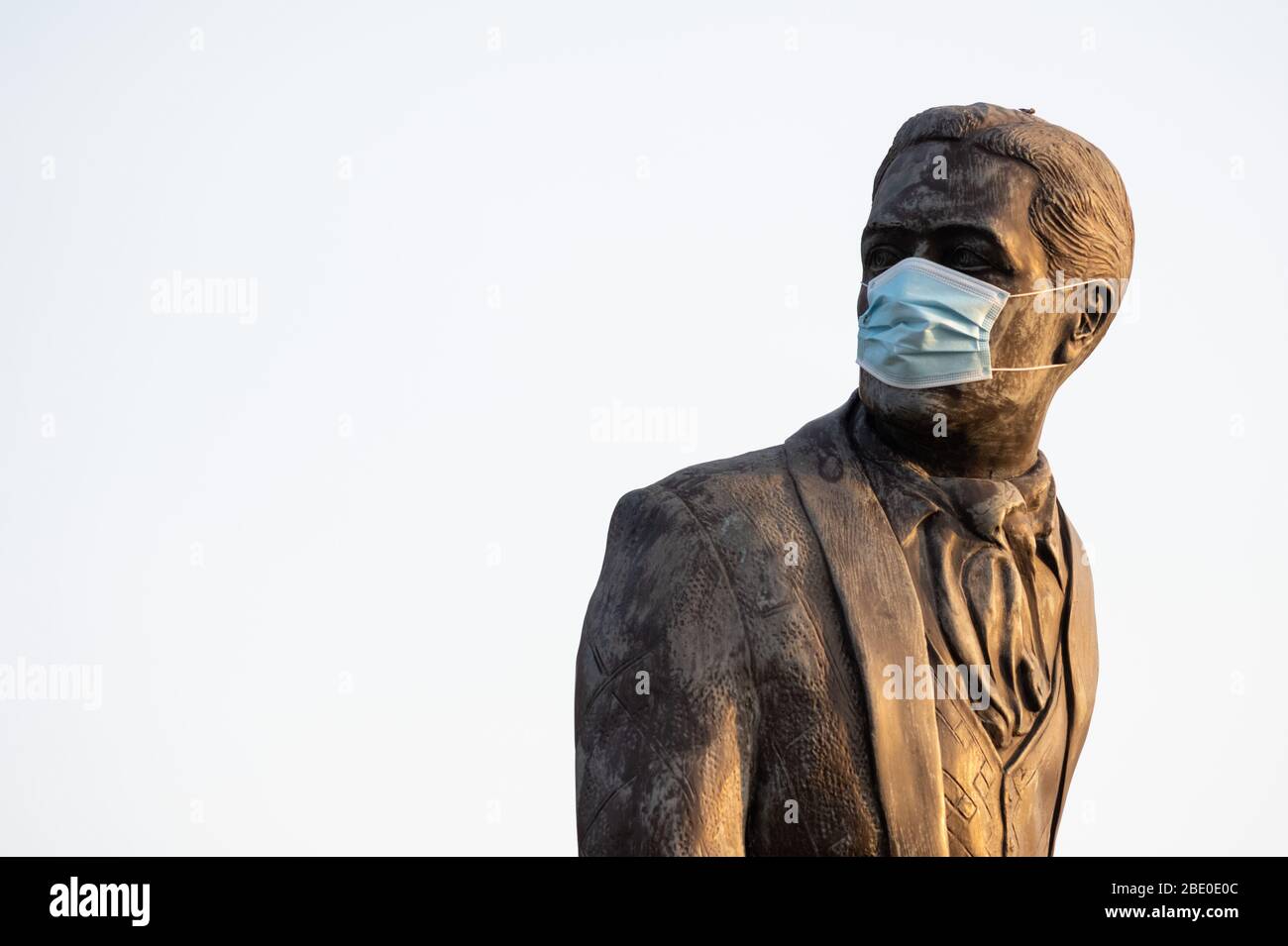 Die Ivor Novello Statue in Cardiff Bay, Wales, UK, trägt eine blaue chirurgische Gesichtsmaske während des Coronavirus (COVID-19) Lockdown. Stockfoto