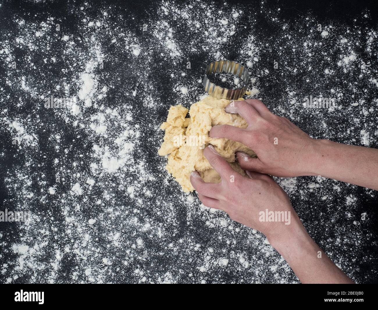 Hände der Frau kneten Scones Teig. Draufsicht Stockfoto