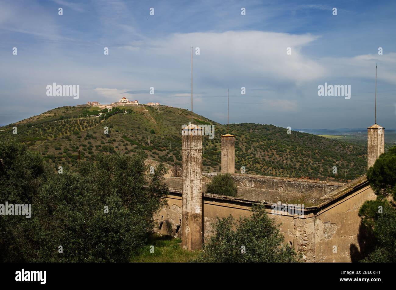 Alte und verlassene Santa Barbara Munitionsdepot vor den Mauern von Elvas zusammen mit dem Blick auf Graca Festung Hügel im Hintergrund. Getrübte blaue s Stockfoto