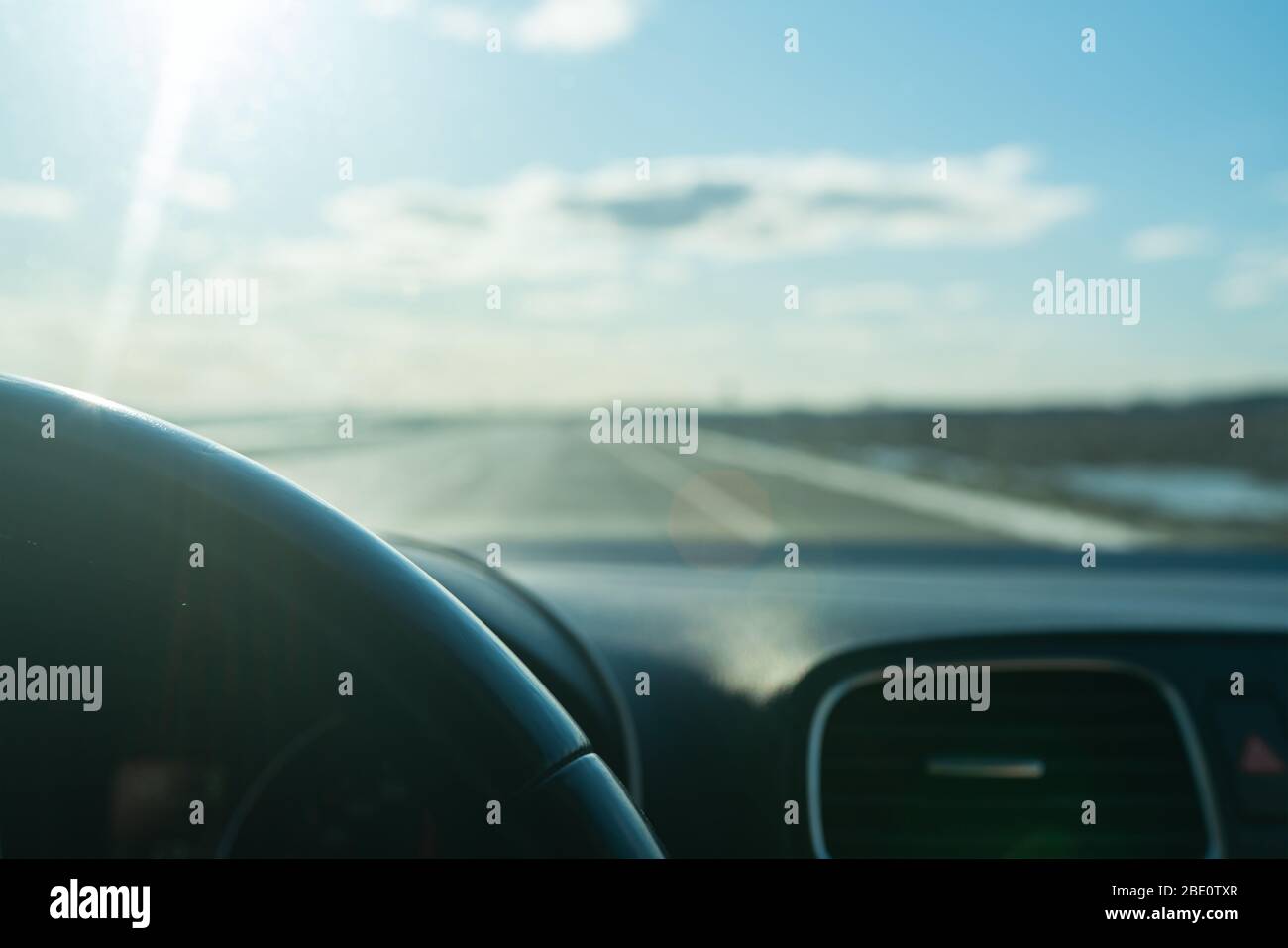Blick aus dem Inneren des fahrenden Autos auf der Straße, Blue Sky. Transportkonzept. Lels-Reflexe. Selektiver Fokus. Stockfoto
