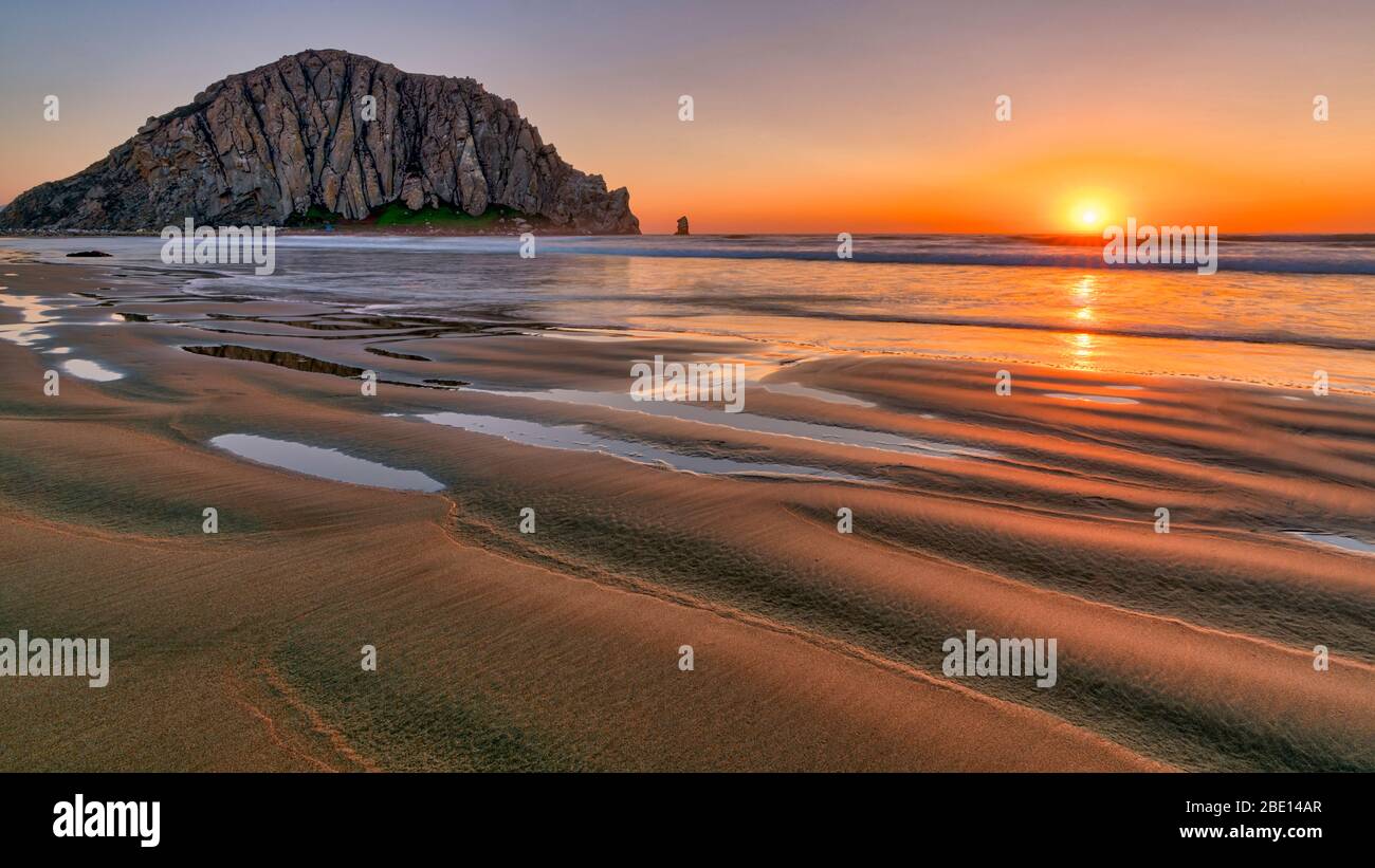 Sonnenuntergang über dem Sandstrand von Morro Rock Stockfoto