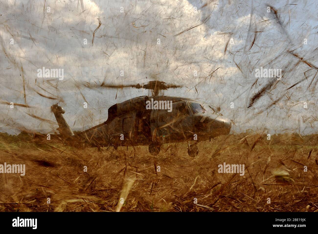 Ein U.S. Navy HH-60 Bereitet in einem Feld zu landen, und Abholen, US Air Force Combat Controller und US-Armee Pfadfinder Durchführung einer Drop Zone Umfrage für zukünftige Air drop Websites am 24. Januar 2010 in Port-au-Prince, Haiti während des Betriebs einheitliche Antwort. Stockfoto