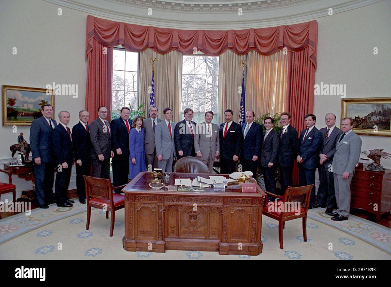 3-24 -1988 Präsident Reagan während einer Fotogelegenheit mit leitenden Mitarbeitern des Nationalen Sicherheitsrates NSC Personal John Negroponte, Colin Powell, Paul Stevens, William Cockell, Herman Cohen, Stephen Danzansky, Robert Dean, Fritz Ermarth, Alison Fortier, D Barry Kelly, James Kelly, Robert Linhard, Robert Oakley, Peter Rodman, Nicholas Rostow und Jose Sorzano im Oval Office Stockfoto