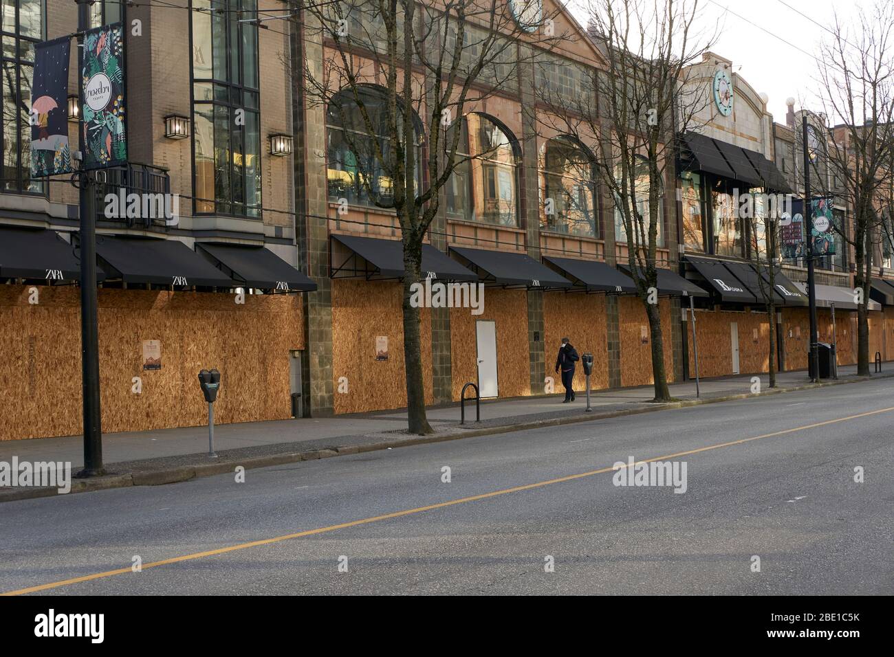 Vancouver, Kanada, 10. April 2020. Während der COVD-19-Pandemie geht ein Mann an den vernagelten Geschäften in der Robson Street in der Innenstadt von Vancouver vorbei. Stockfoto