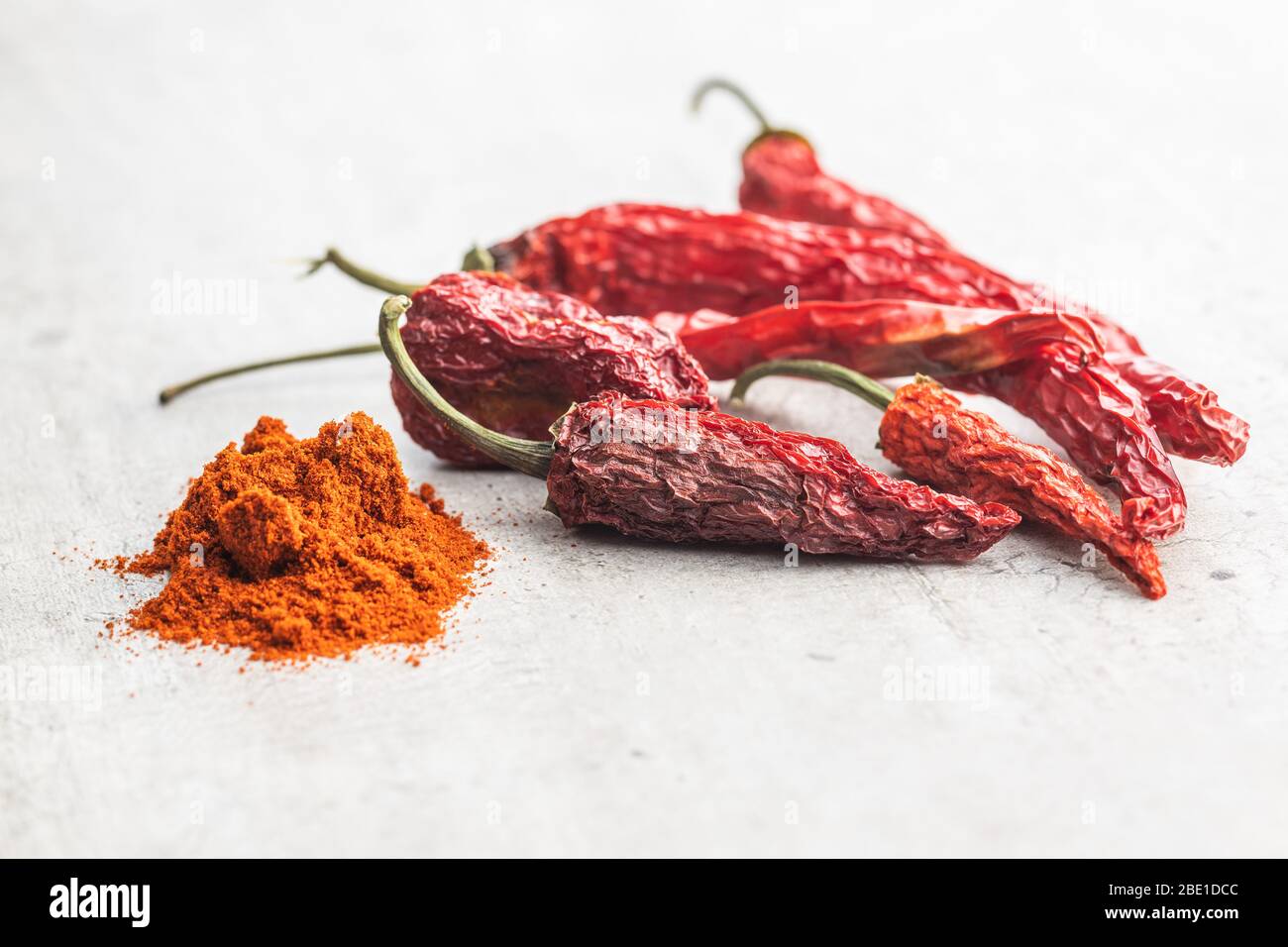 Getrocknete rote Chilischoten und Chilipulver Gewürz auf Küchentisch. Stockfoto