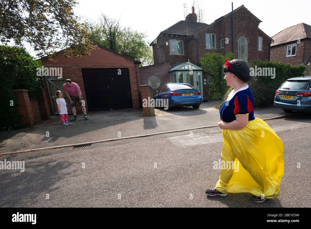 Stockport, Greater Manchester, Großbritannien. April 2020. Rebecca Williamson, ein Mädchen in schneeweißen Kostümen, jubelt Menschen an, die sich am 10. April 2020 in Stockport bei Manchester, Großbritannien, bei der COVID-19-Pandemie befinden. Rebecca, eine von denen, die als Comic-Bücher oder Märchenfiguren verkleidet, versuchte, die Menschen in der Öffentlichkeit während der Epidemie Ausbruch aufzumuntern. Kredit: Jon Super/Xinhua/Alamy Live News Stockfoto