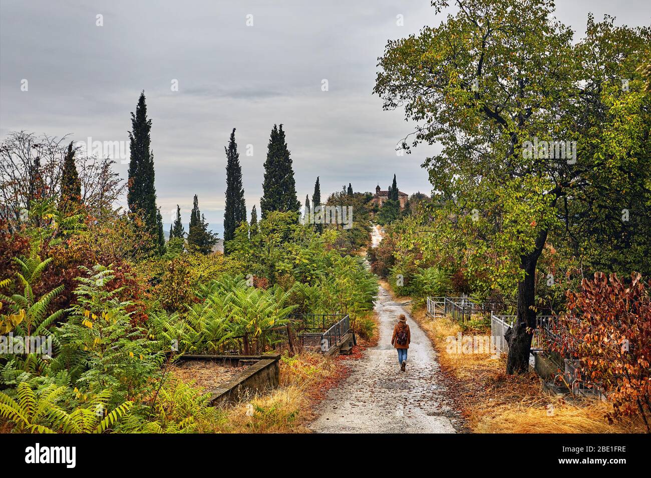 Touristische Frau in hat zu Fuß die Straße runter am Friedhof an der Herbst in Signagi, Georgien Stockfoto