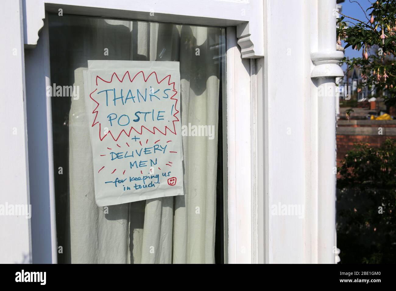 Selbstgemachte Zeichen in einem Hausfenster danken Postboten und Deliverymen während der Coronavirus Sperrung Stockfoto