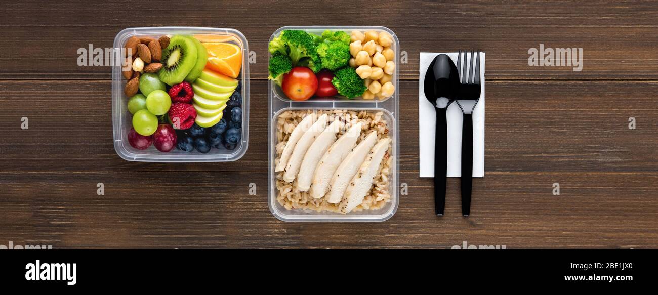 Draufsicht der gesunden nährstoffreichen Lebensmittel in Take Away Boxen mit Löffel und Gabel auf Holz Tisch Banner Hintergrund gesetzt Stockfoto