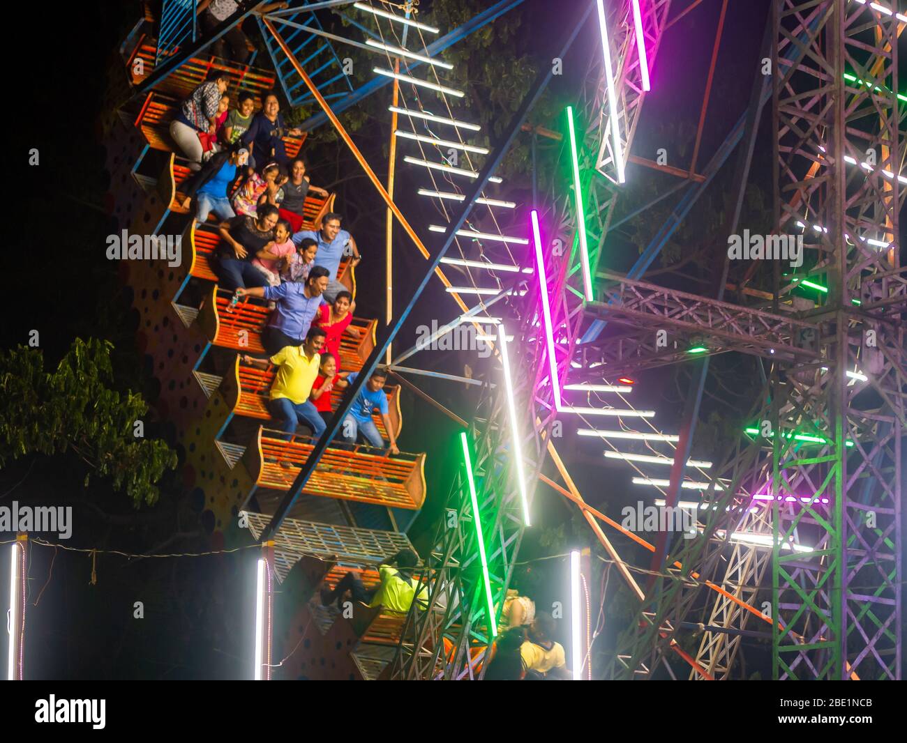 Mumbai, Indien - 01. Dezember 2019: Indische Familie genießt spannende Fahrt im Vergnügungspark bei Nacht beleuchtet Stockfoto