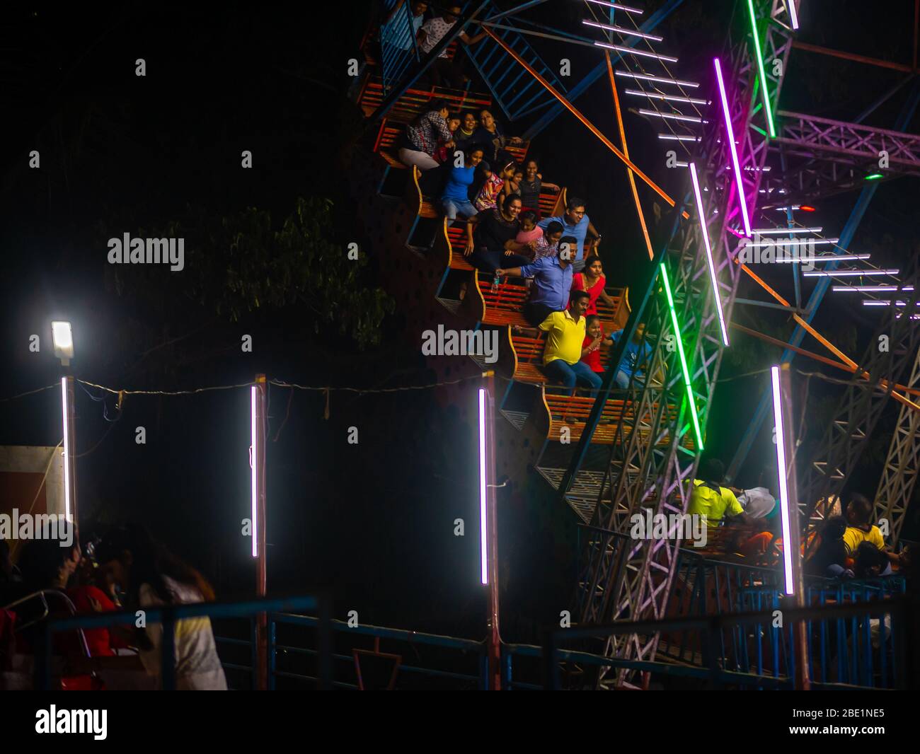 Mumbai, Indien - 01. Dezember 2019: Indische Familie genießt spannende Fahrt im Vergnügungspark bei Nacht beleuchtet Stockfoto