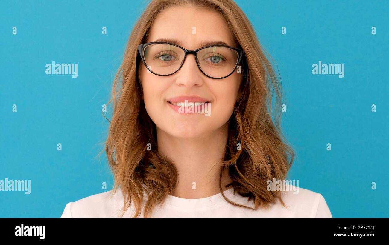 Junge Frau, die eine Brille aufsetzt Stockfoto