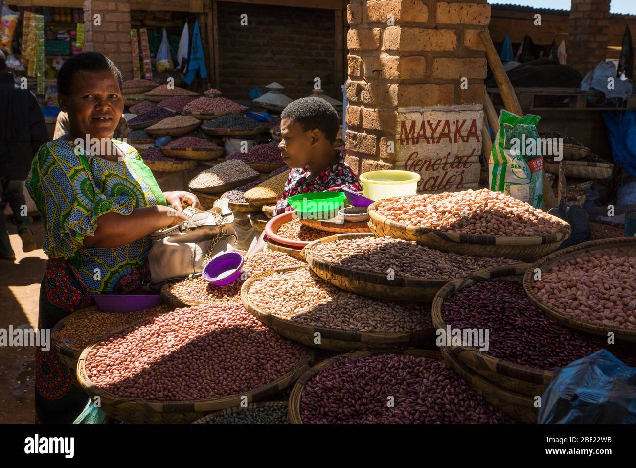 Frau, die Bohnen und Hülsenfrüchte auf dem Mzuzu-Markt im Norden Malawis verkauft Stockfoto