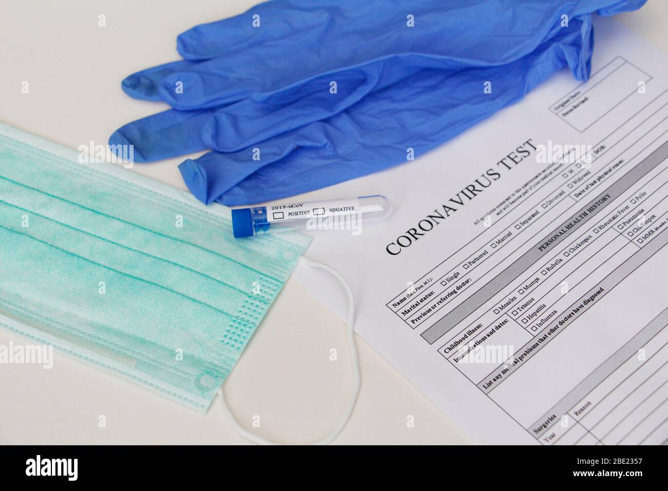 Coronavirus-Labortest. Konzept. Auf dem Tisch ist ein Reagenzglas, Latex medizinische Handschuhe, eine Gesichtsmaske und Zustimmung, um Tests zu nehmen. Es gibt niemanden. Stockfoto