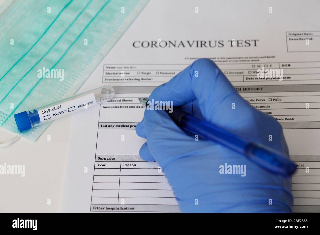 Laborversuch zur Bestimmung des Coronavirus. Konzept. Der Patient füllt die Einwilligungserklärung zur Analyse aus. Das Reagenzglas sagt POSITIV und NEGATIV Stockfoto