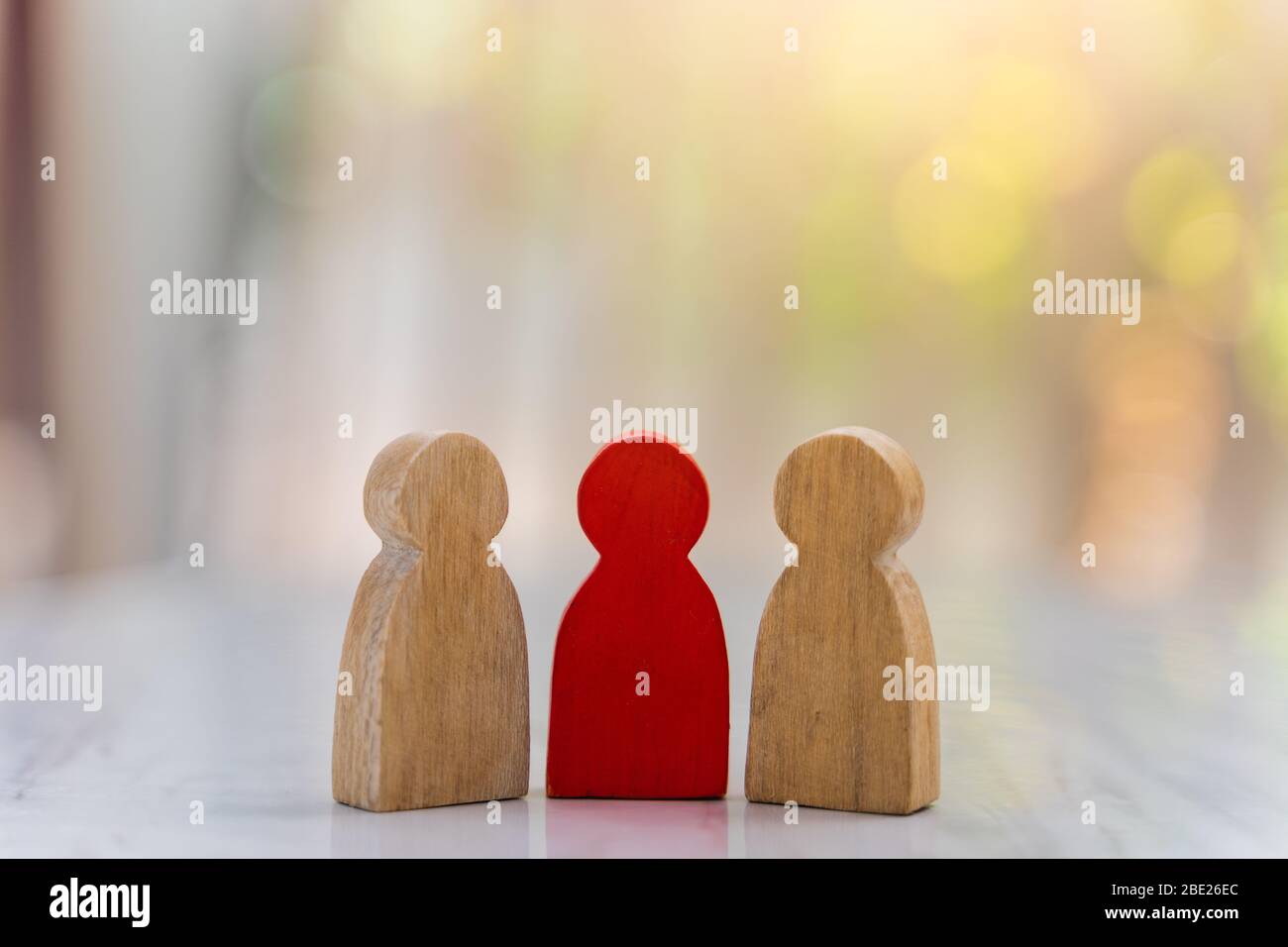 Abbildung im Konzept des Personalmanagements. Die Gruppe der Holzpuppen EINE rote Holzfigur wie eine Dominante in einer Gruppe mit unscharfen Bokeh Hintergrund Stockfoto