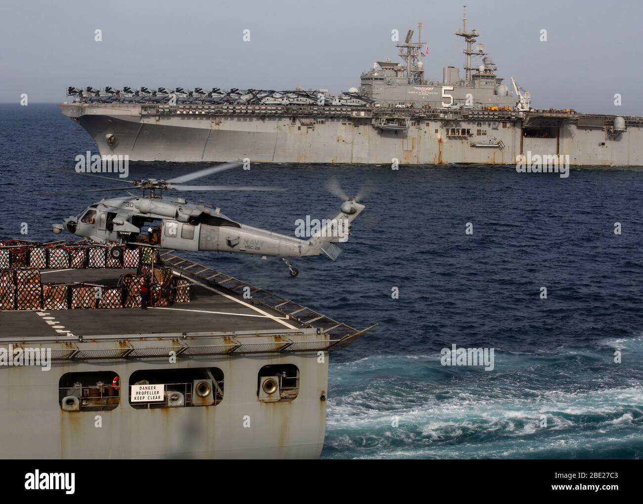 200408-M-MV109-1079 5. EINSATZGEBIET der US-FLOTTE (8. April 2020) EIN US-Navy MH-60S Sea Hawk, der dem amphibischen Sturmschiff USS Bataan (LHD-5) zugewiesen wurde, holt Paletten vom Kampfdeck des Trockenfracht- und Munitionsschiffes USNS William McLean (T-AKE-12) während einer Wiederauffüllung auf See 8. April 2020 ab. Bataan, mit eingeschifften 26. Marine Expeditionary Unit wird in den 5. US-Flottenbereich eingesetzt, um die Seestandlagen zu unterstützen, um die maritime Stabilität und Sicherheit in der Zentralregion zu gewährleisten, indem es das Mittelmeer und den Pazifik durch den westlichen Indischen Ozean und drei Strate verbindet Stockfoto